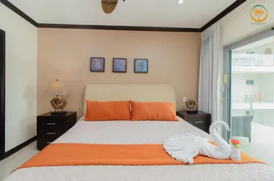 a bedroom with a bed with a swan on it at Modern Condominium Beachfront Jaco Beach, Diamante del Sol in Jacó