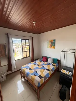a bedroom with a bed and a window at Apartamentos casco in Heredia