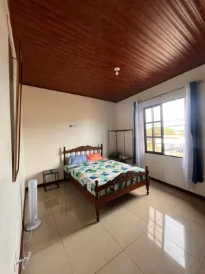 a bedroom with a bed and a large window at Apartamentos casco in Heredia