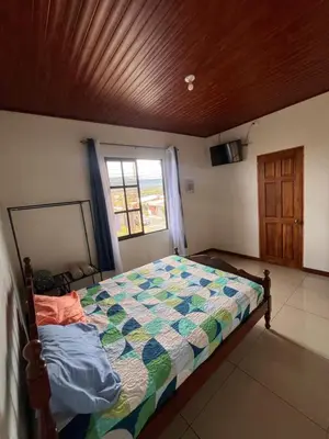 a bedroom with a bed and a window at Apartamentos casco in Heredia