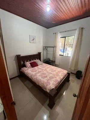a bedroom with a bed and a window at Apartamentos casco in Heredia