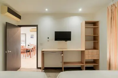 a bedroom with a desk with a tv on a wall at Spacious 2BR Condo with Partial Ocean View- Roble Sabana- Reserva Conchal in Playa Conchal