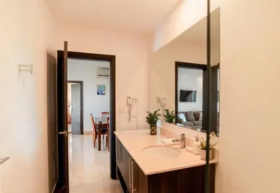 a bathroom with a sink and a mirror at Spacious 2BR Condo with Partial Ocean View- Roble Sabana- Reserva Conchal in Playa Conchal