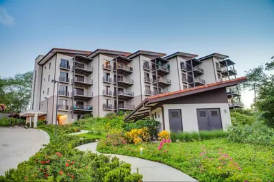 an apartment building with a garden in front of it at Spacious 2BR Condo with Partial Ocean View- Roble Sabana- Reserva Conchal in Playa Conchal