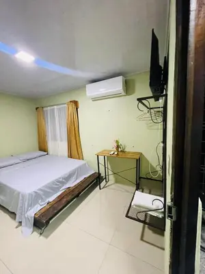 a bedroom with a bed and a flat screen tv at Cabinas Marielos in Sarapiquí