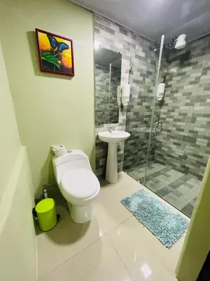 a bathroom with a toilet and a sink and a shower at Cabinas Marielos in Sarapiquí