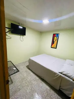 a bedroom with a bed and a flat screen tv at Cabinas Marielos in Sarapiquí
