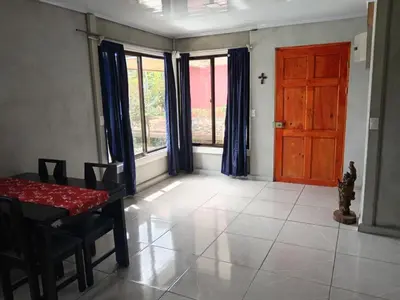 a dining room with a table and a red door at Casa Pura Vida Arenal in Tanque
