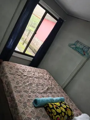 a bed in a room with a window and a bed with a bedspread at Casa Pura Vida Arenal in Tanque