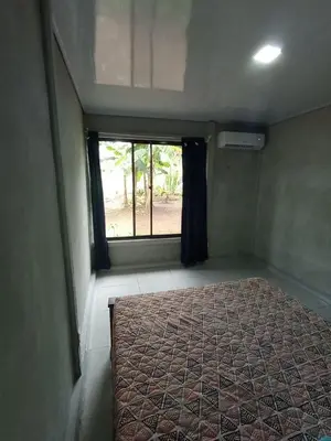 a bedroom with a bed in a room with a window at Casa Pura Vida Arenal in Tanque