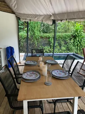 a wooden table with plates and candles on it at Safari tent with private pool close to Manuel Antonio Glamping 2 in Savegre