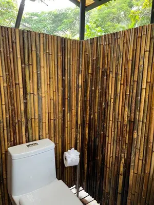 a toilet in front of a wooden fence at Safari tent with private pool close to Manuel Antonio Glamping 2 in Savegre