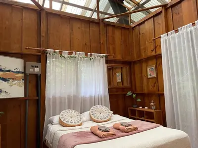 a bedroom with a bed with wooden walls at River Cabin 1BR Breathtaking Chirripó Retreat in Tapantí