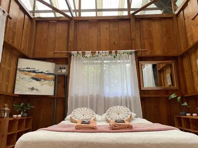 a bedroom with a bed with wooden walls and a window at River Cabin 1BR Breathtaking Chirripó Retreat in Tapantí