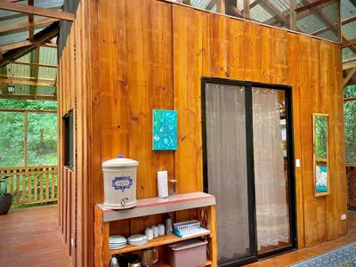 a room with a wooden wall with a door in a house at River Cabin 1BR Breathtaking Chirripó Retreat in Tapantí