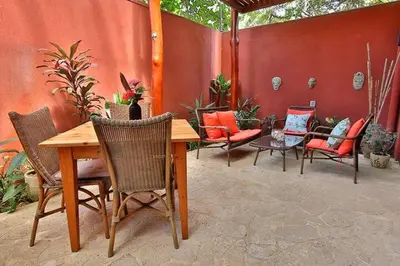 a patio with a wooden table and chairs at Stef Surf Villa El Delfin in Potrero