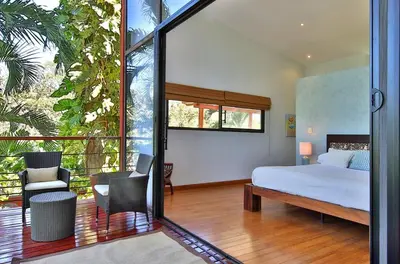 a bedroom with a bed and a large window at Stef Surf Villa El Delfin in Potrero