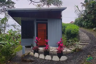 a small house with pink flowers in a garden at Hospedaje Oropéndola in Quesada