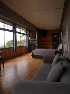 a living room with two beds and a couch at Hospedaje Oropéndola in Quesada