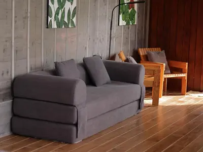 a couch in a living room with a table and chairs at Hospedaje Oropéndola in Quesada