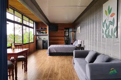 a living room with a bed and a couch at Hospedaje Oropéndola in Quesada
