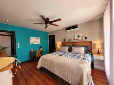 a bedroom with a bed and a ceiling fan at Walk to Downtown Santa Ana, Near Airport, Lush Gardens, Pool, King Bed, Security in Santa Ana