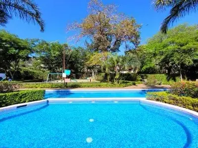a large blue swimming pool in a yard at Walk to Downtown Santa Ana, Near Airport, Lush Gardens, Pool, King Bed, Security in Santa Ana