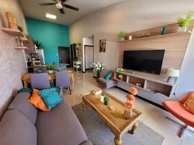 a living room with a couch and a table and a tv at Walk to Downtown Santa Ana, Near Airport, Lush Gardens, Pool, King Bed, Security in Santa Ana