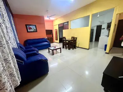 a living room with a blue couch and a table at Pura Vida Stay Liberia in Liberia