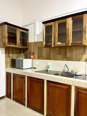 a kitchen with wooden cabinets and a sink at Pura Vida Stay Liberia in Liberia