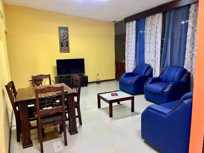 a living room with a table and chairs and a tv at Pura Vida Stay Liberia in Liberia