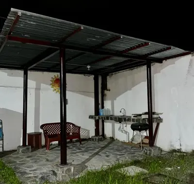 a pergola with a table and two chairs under it at Pura Vida Stay Liberia in Liberia