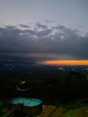 a view of a sunset from the top of a building at Hygge House with a view of the Arenal Volcano and the San Carlos Plain in Vieja