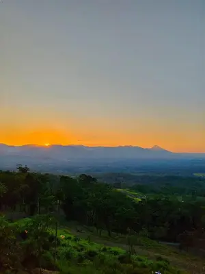 a view of the sunset from a hill with trees at Hygge House with a view of the Arenal Volcano and the San Carlos Plain in Vieja