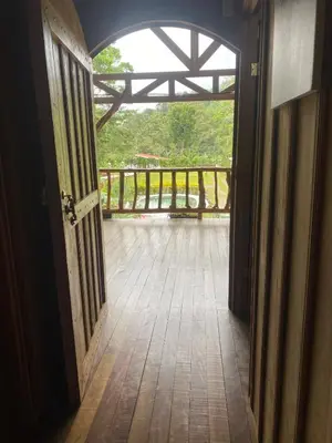 an open door to a porch with a wooden deck at Cabin -Treehouse La Tigra in San Gerardo