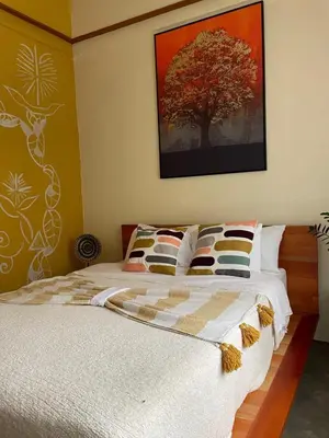a bedroom with a bed with a tree on the wall at Zen Mountain Escape 3BR Getaway near Chirripó in Rivas