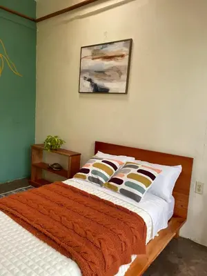 a bedroom with a bed and a painting on the wall at Zen Mountain Escape 3BR Getaway near Chirripó in Rivas