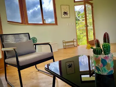 a living room with a chair and a glass table at House on the Hill 1BR Costa Rica Jungle Escape in Rivas