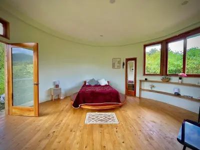 a bedroom with a bed in a room with windows at House on the Hill 1BR Costa Rica Jungle Escape in Rivas