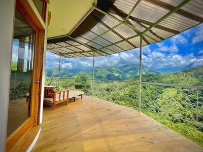 a room with a balcony with a view of the mountains at House on the Hill 1BR Costa Rica Jungle Escape in Rivas