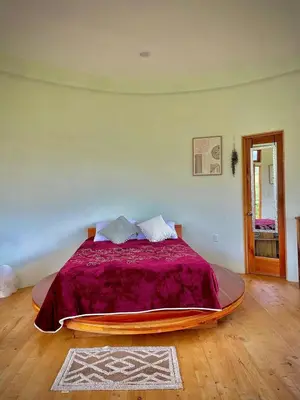 a bedroom with a large bed with a purple blanket at House on the Hill 1BR Costa Rica Jungle Escape in Rivas