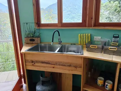 a kitchen with a stainless steel sink and two windows at House on the Hill 1BR Costa Rica Jungle Escape in Rivas