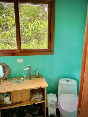a bathroom with a sink and a toilet and a window at House on the Hill 1BR Costa Rica Jungle Escape in Rivas