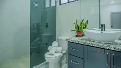 a white bathroom with a sink and a toilet at Modern Retreat in the Rainforest with River Access in Ojochal