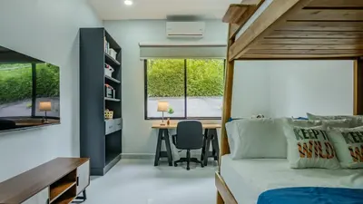 a bedroom with a bed and a desk and a table at Modern Retreat in the Rainforest with River Access in Ojochal