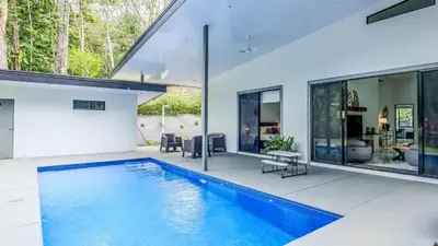 a swimming pool in the backyard of a house at Modern Retreat in the Rainforest with River Access in Ojochal