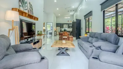 a living room with two couches and a table at Modern Retreat in the Rainforest with River Access in Ojochal