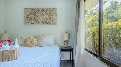 a bedroom with a bed and a large window at Tropical 3 Cozy Cabins with Pool in Central Uvita in Uvita