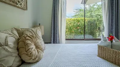 a bedroom with a bed and a large window at Tropical 3 Cozy Cabins with Pool in Central Uvita in Uvita