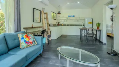 a living room with a blue couch and a glass table at Tropical 3 Cozy Cabins with Pool in Central Uvita in Uvita